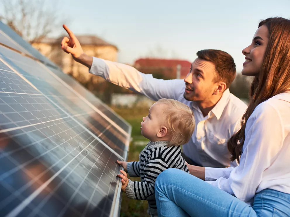 Una famiglia felice accanto a un pannello solare